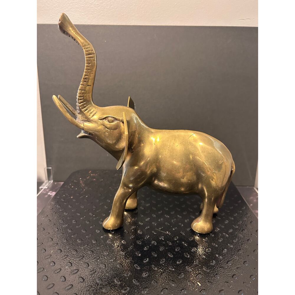 vintage brass elephant figurine features a raised trunk